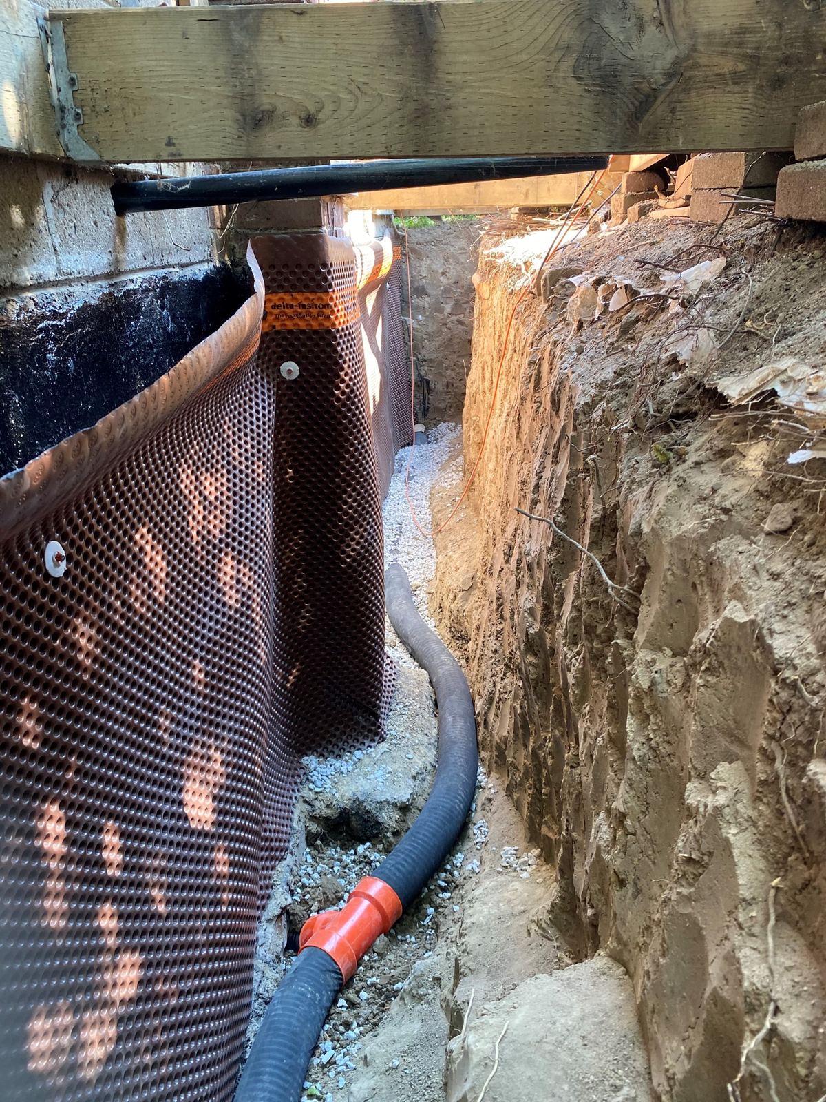 Exterior foundation waterproofing with drainage membrane and weeping tile