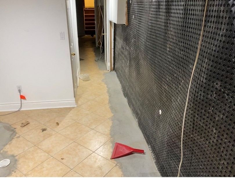 Completed interior basement waterproofing system along the wall